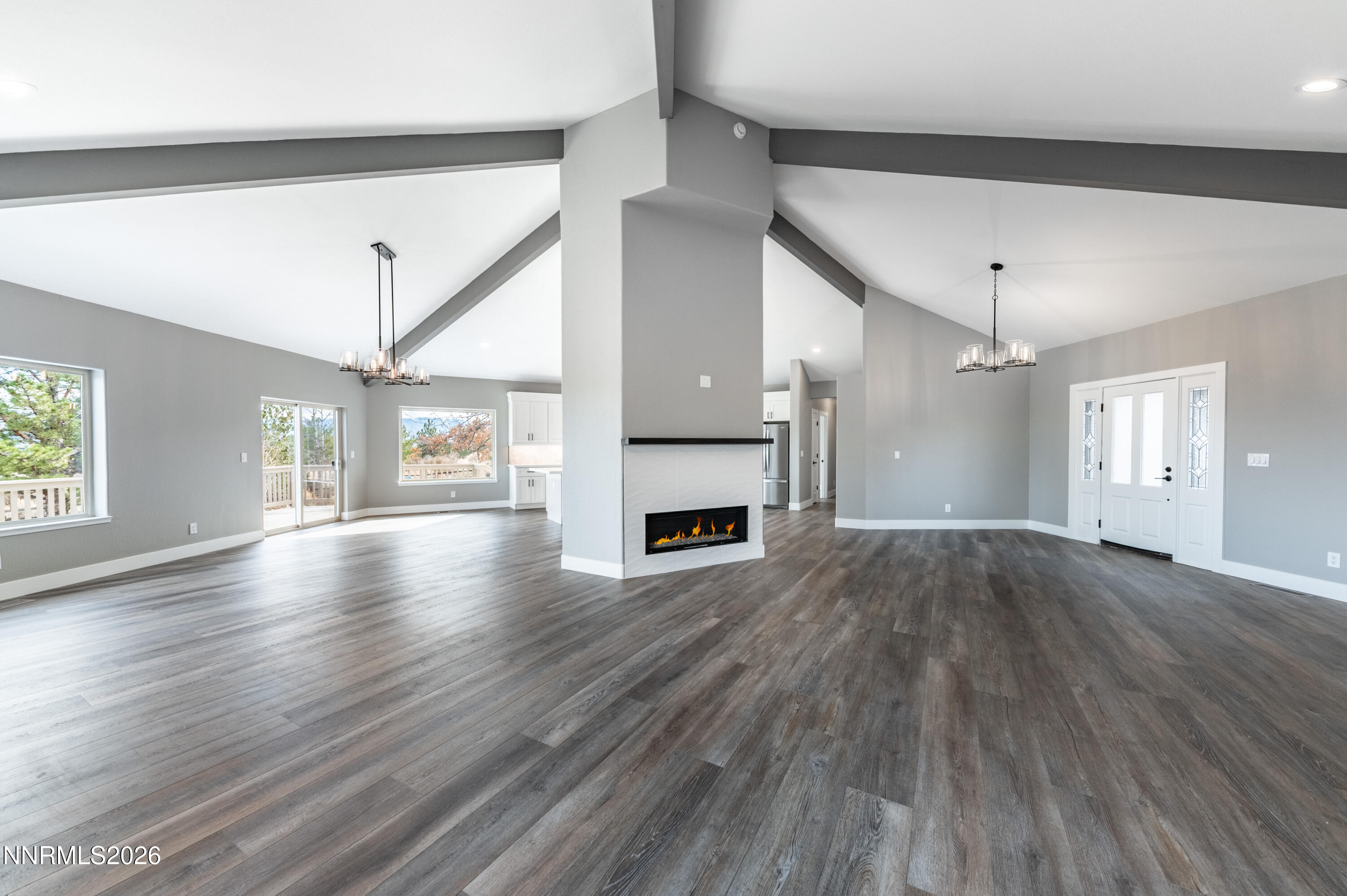 14330 East Windriver Lane Reno, NV 89511 - Photo 17 of 36 a view of a livingroom with wooden floor a fireplace window and a kitchen space