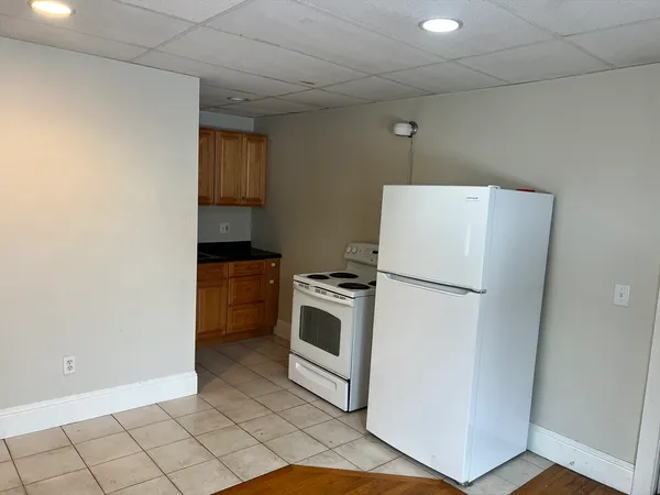 a white refrigerator freezer and a stove sitting inside of a kitchen