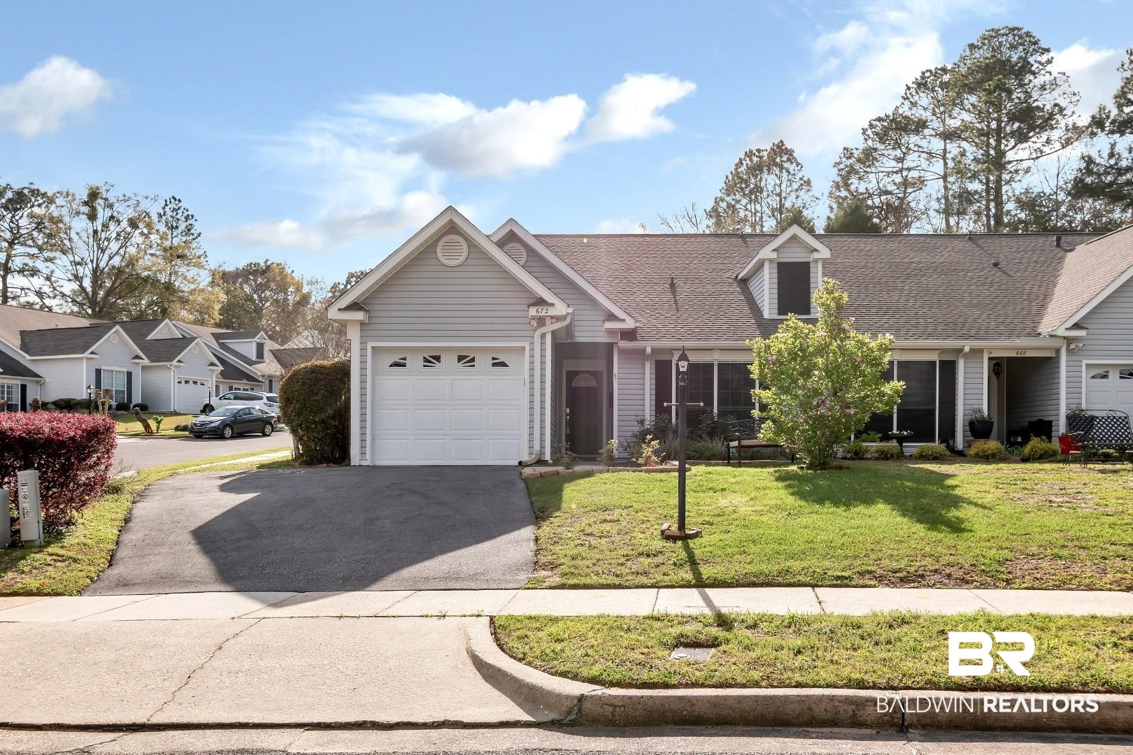 672 Spring Lake Drive East Mobile, AL 36695 - Photo 25 of 26 View of front of property featuring driveway, a front lawn, roof with shingles, and an attached garage