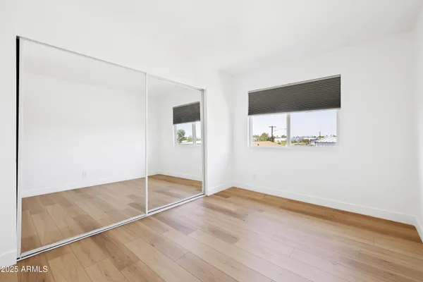an empty room with wooden floor and cabinet