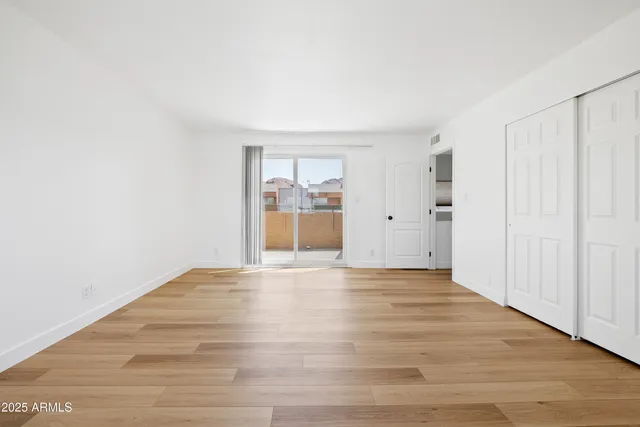 a view of empty room with wooden floor
