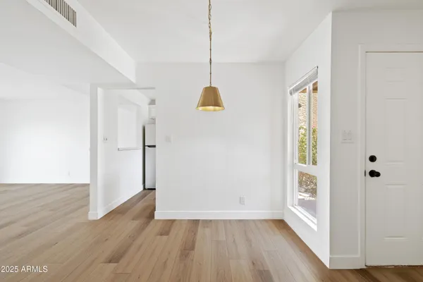 a view of an entryway with wooden floor and cabinet door