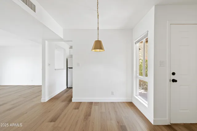 a view of an entryway with wooden floor and cabinet door