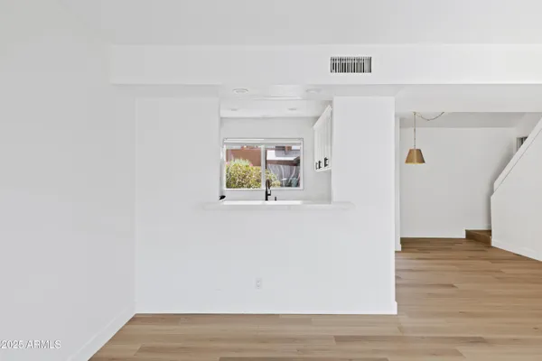 a view of a hallway with wooden floor and cabinet