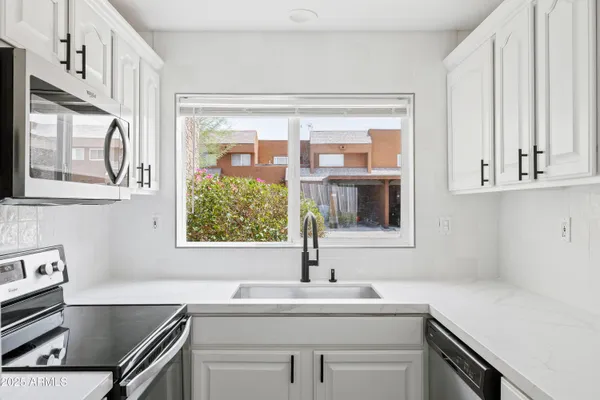 a kitchen with stainless steel appliances a sink stove and cabinets