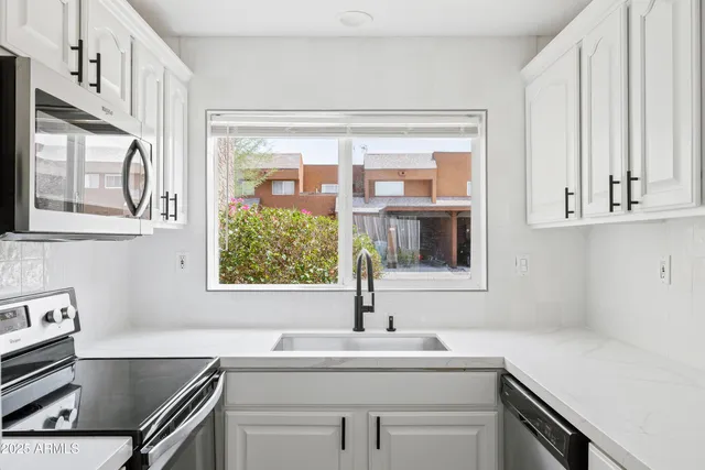 a kitchen with stainless steel appliances a sink stove and cabinets