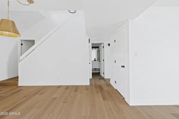 a view of a hallway with wooden floor and entryway