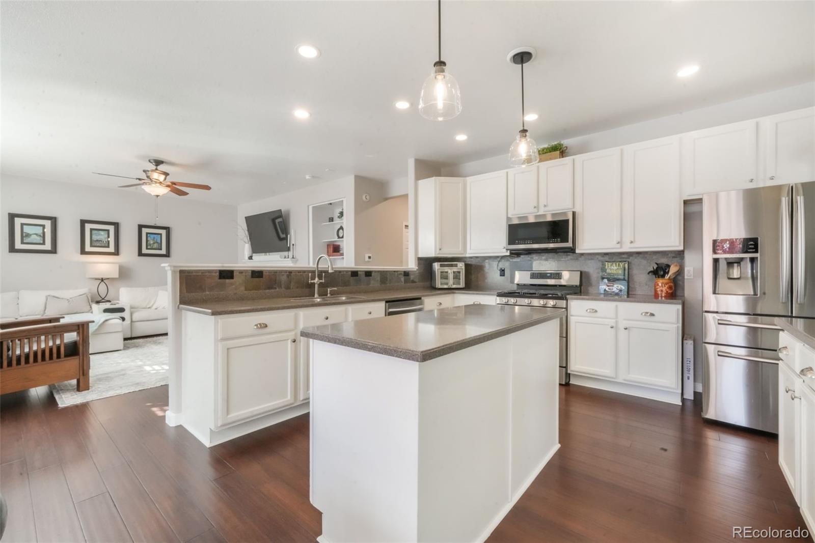 4457 Centerville Drive Colorado Springs, CO 80922 - Photo 14 of 50 a kitchen with stainless steel appliances white cabinets a sink and a refrigerator