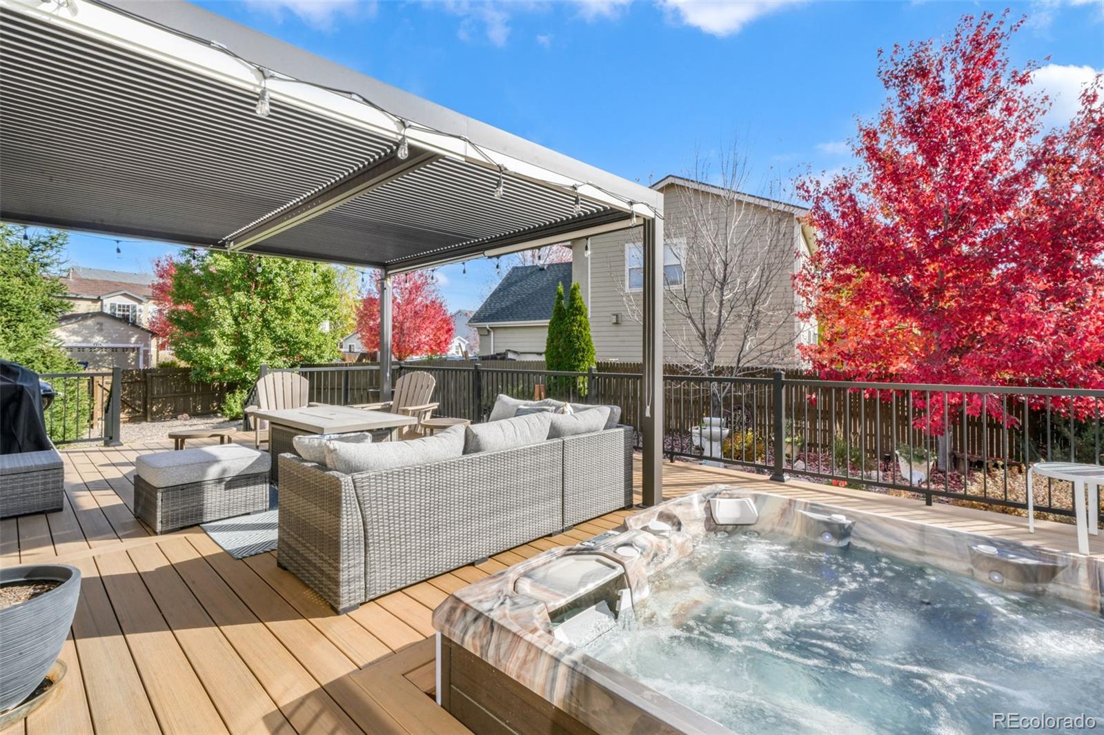 4457 Centerville Drive Colorado Springs, CO 80922 - Photo 18 of 50 a view of a patio with couches and table and chairs under an umbrella