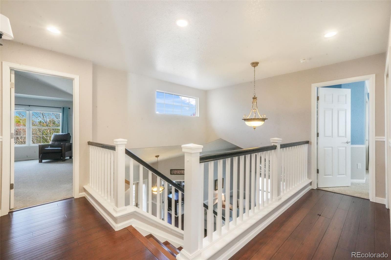 4457 Centerville Drive Colorado Springs, CO 80922 - Photo 24 of 50 a view of a hallway with wooden floor and windows