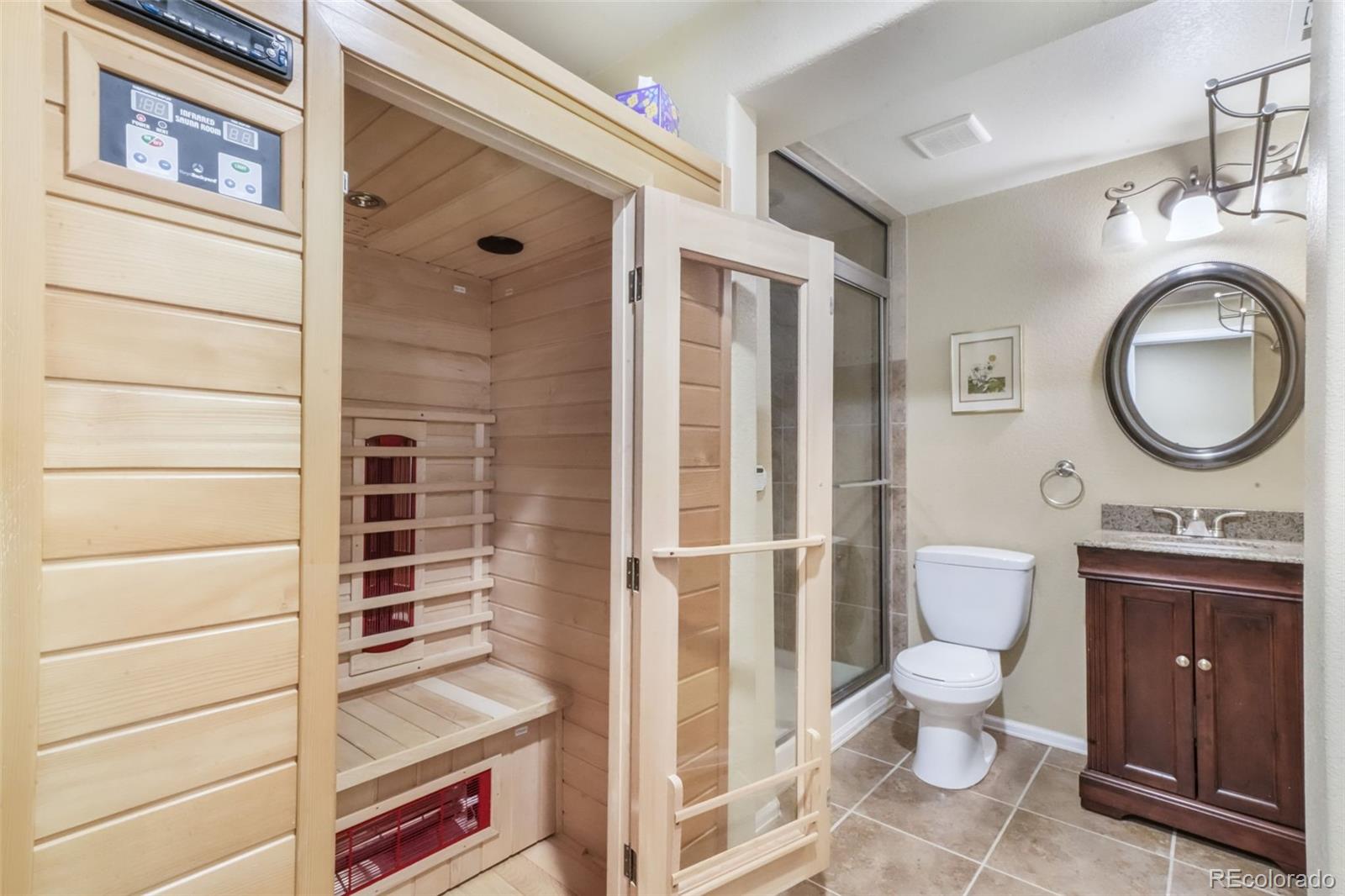 4457 Centerville Drive Colorado Springs, CO 80922 - Photo 50 of 50 a bathroom with a granite countertop toilet sink and mirror
