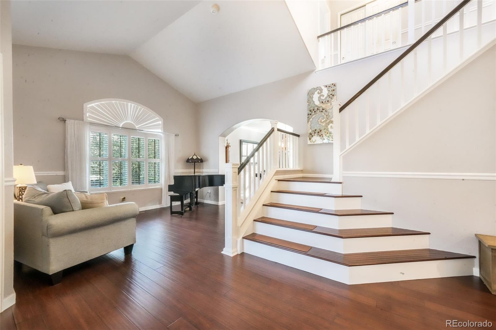 4457 Centerville Drive Colorado Springs, CO 80922 - Photo 7 of 50 a living room with wooden floor and a chandelier