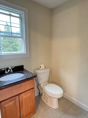a bathroom with a granite countertop toilet and sink