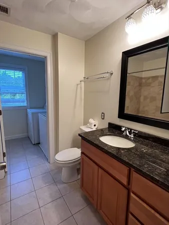 a bathroom with a granite countertop sink a toilet and a mirror