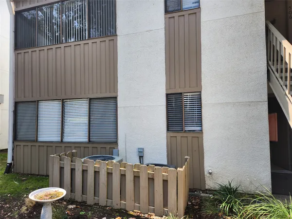 a view of a house with a small yard and wooden fence