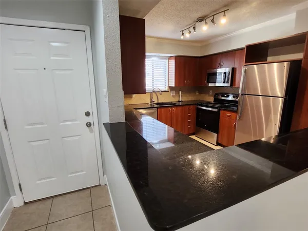 a kitchen with stainless steel appliances a refrigerator a sink a stove and cabinets