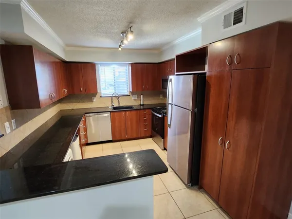 a kitchen with stainless steel appliances granite countertop a refrigerator and a sink