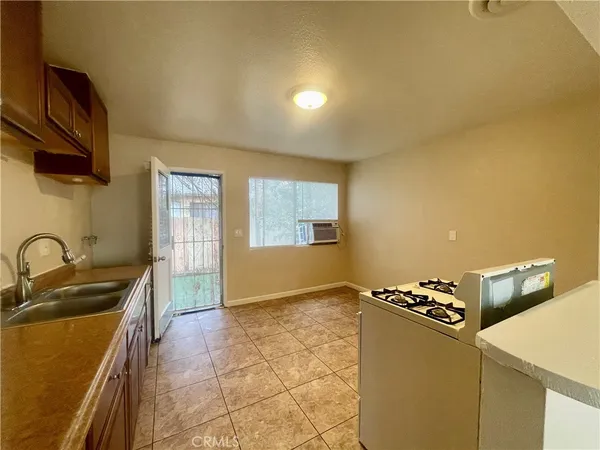 a kitchen with granite countertop a sink a stove and refrigerator