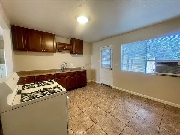a kitchen with cabinets a sink and a stove with wooden floor