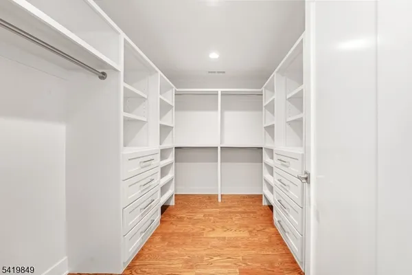 a view of walk in closet with empty racks