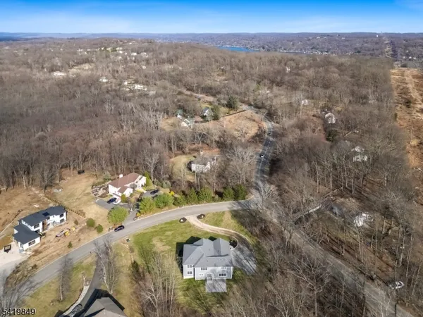 an aerial view of house with yard and mountain view in back