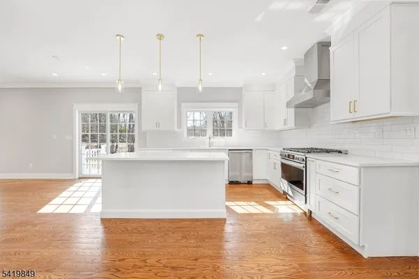 a large kitchen with granite countertop a stove a sink and white cabinets