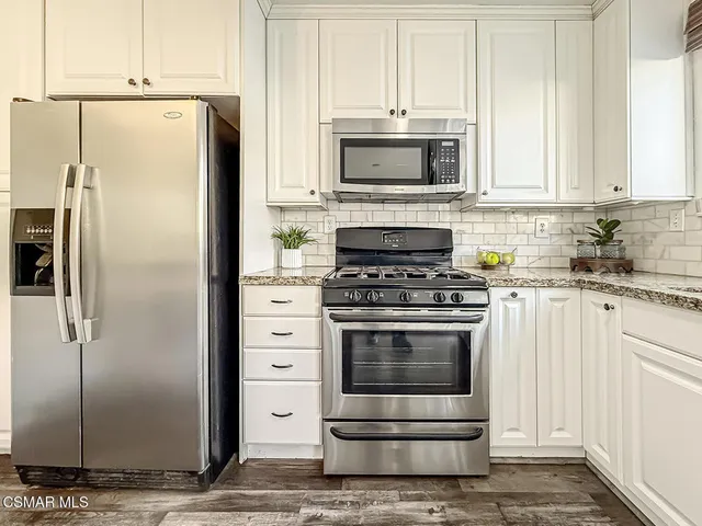 a kitchen with stainless steel appliances white cabinets and a refrigerator