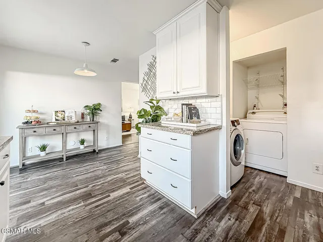 a view of a kitchen with sink and dishwasher with wooden floor