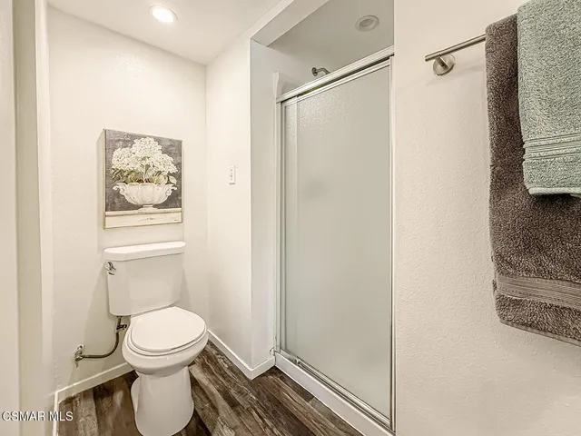 a view of a hallway with wooden floor and a mirror