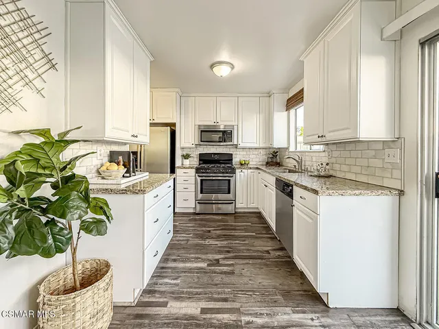 a kitchen with sink a microwave and cabinets