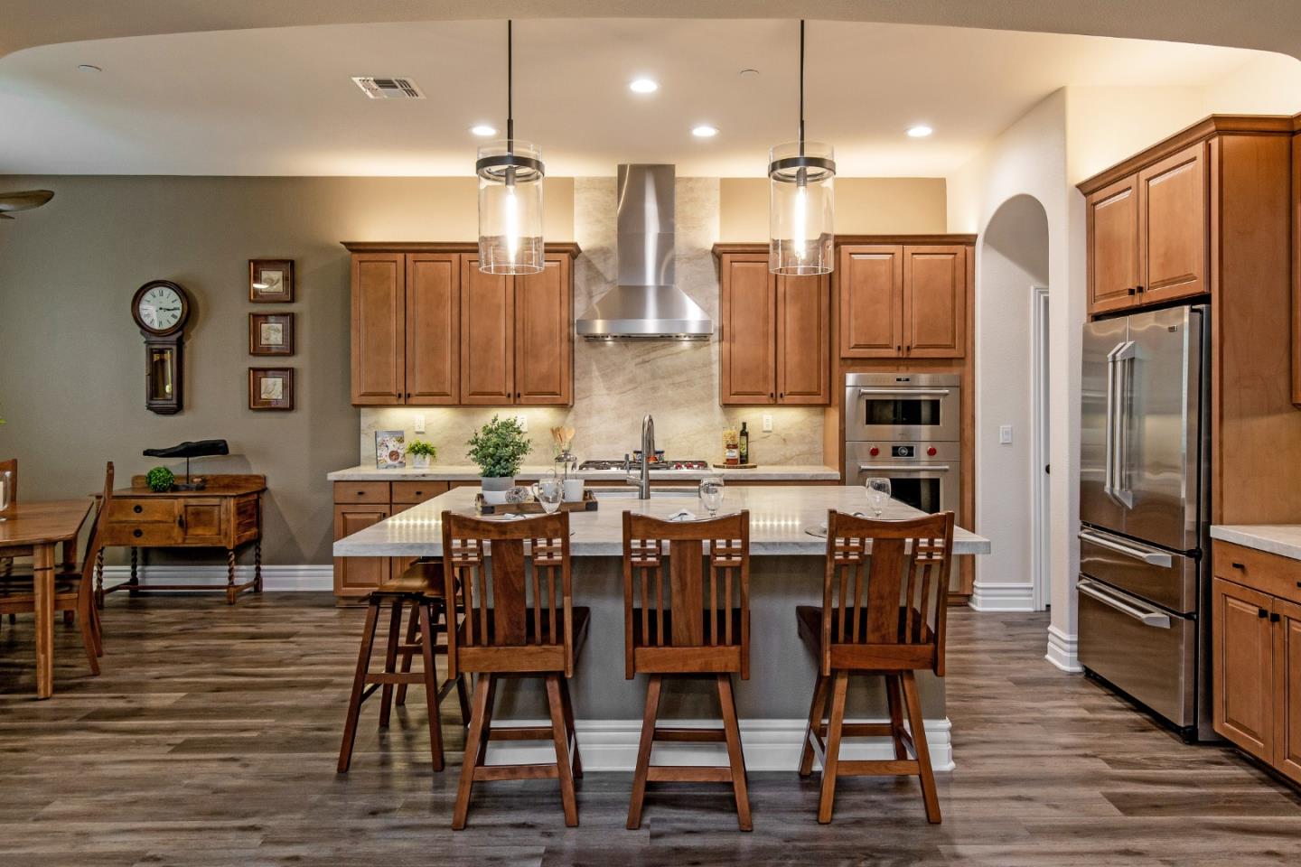 7217 Pitlochry Drive Gilroy, CA 95020 - Photo 9 of 66 a kitchen with stainless steel appliances kitchen island granite countertop a dining table chairs and a refrigerator
