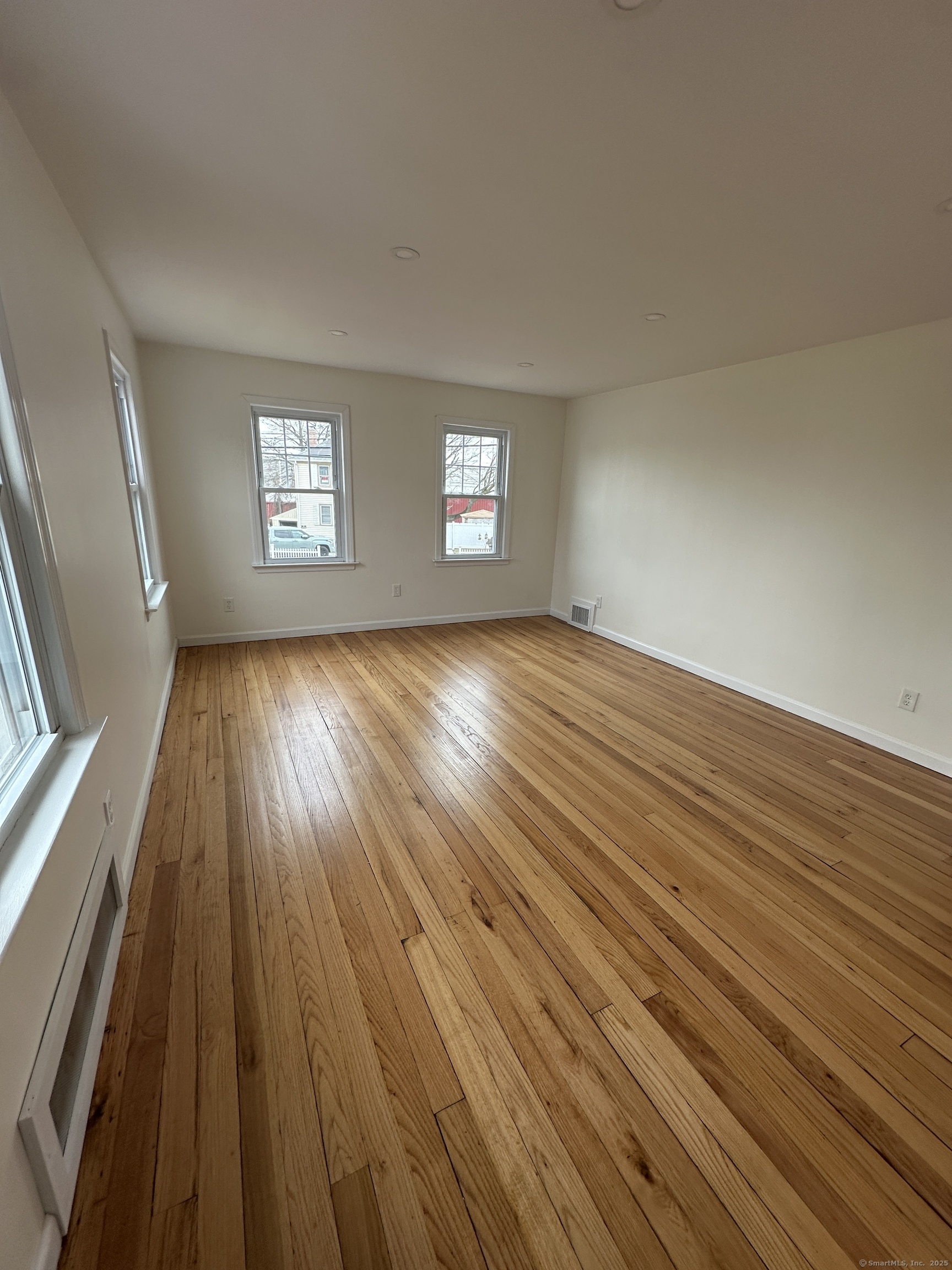 11 Colony Street Stratford, CT 06615 - Photo 8 of 16 an empty room with wooden floor and windows