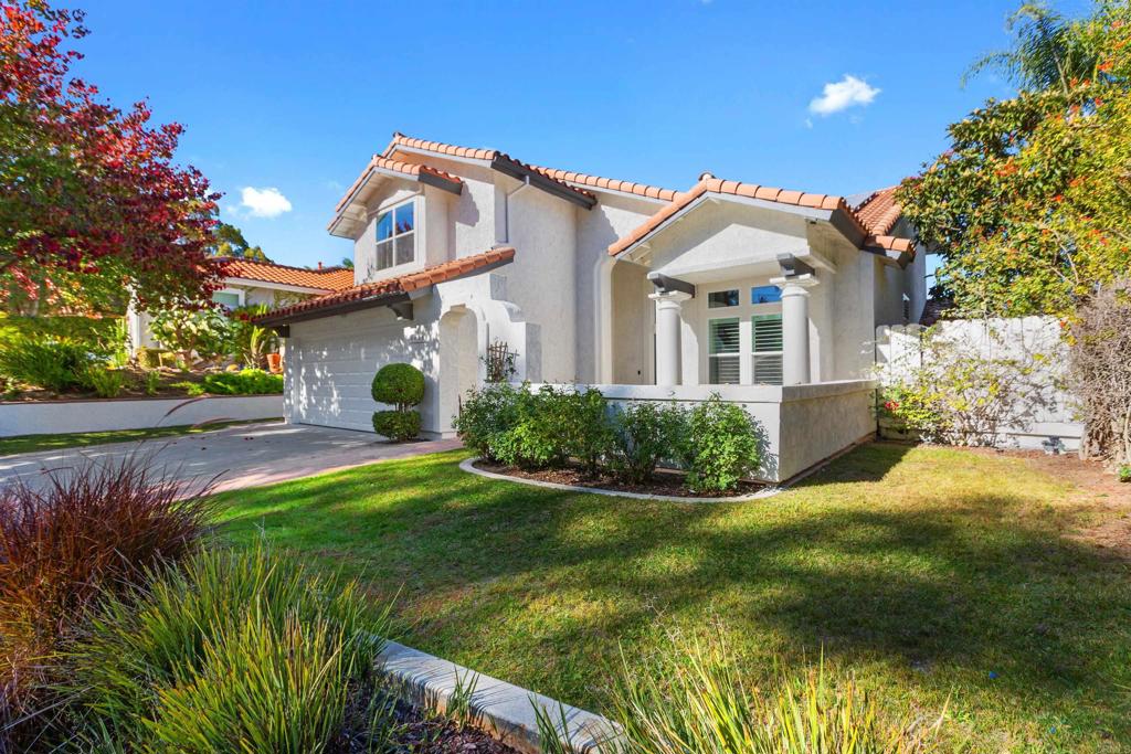 a view of a white house with a big yard and potted plants