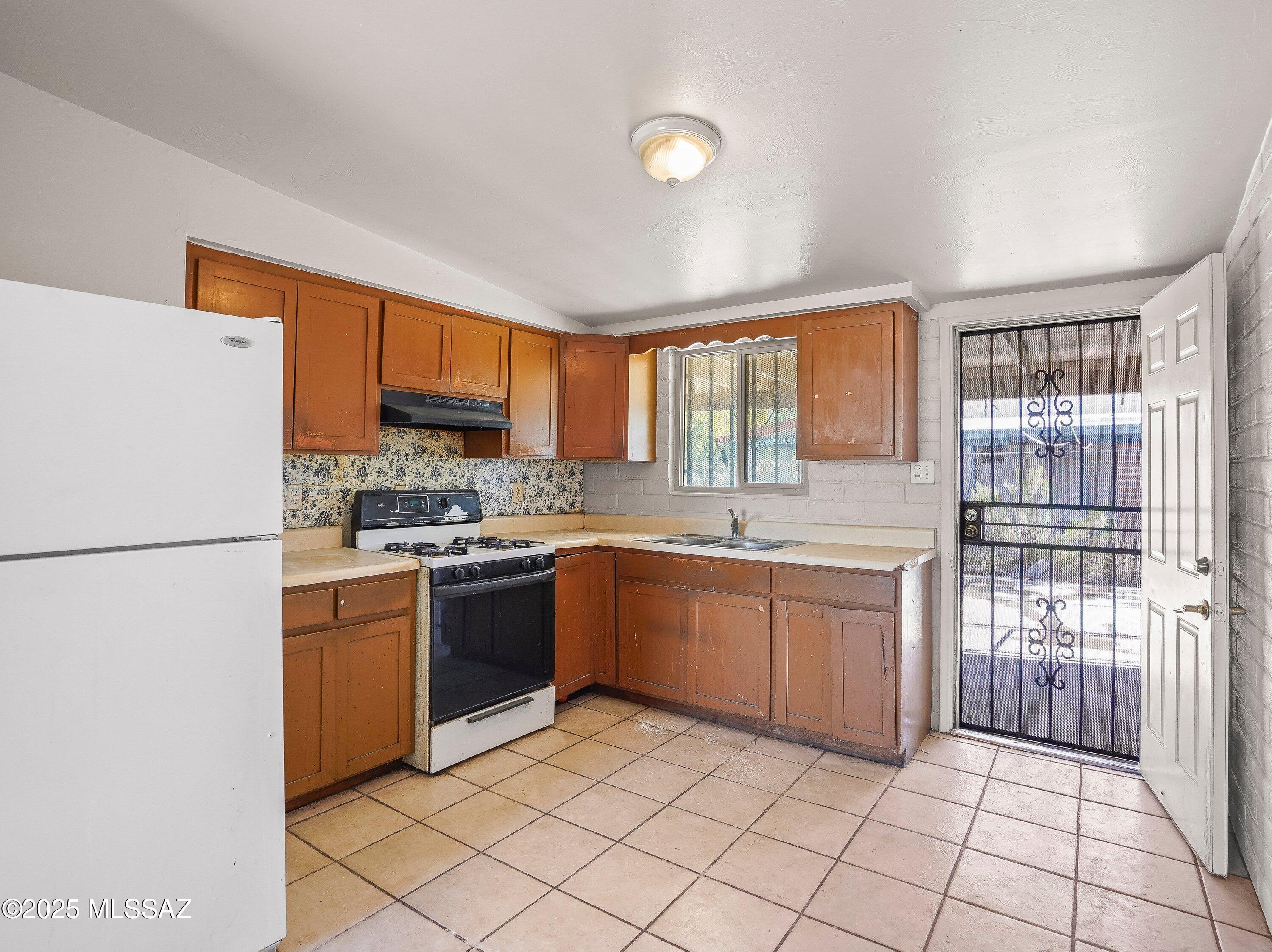 2001 South 3rd Avenue Tucson, AZ 85713 - Photo 28 of 42 a kitchen with stainless steel appliances granite countertop a refrigerator and a stove top oven