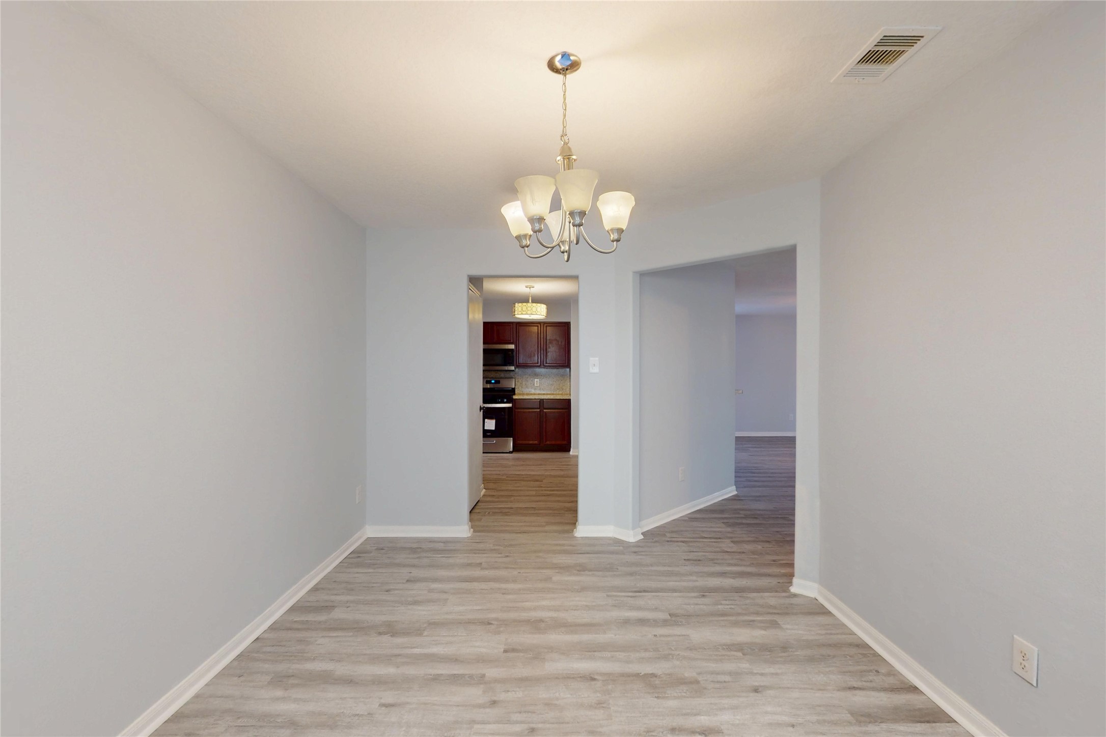 9877 Lace Flower Way Conroe, TX 77385 - Photo 16 of 43 a view of a chandelier in an empty room with a chandelier fan