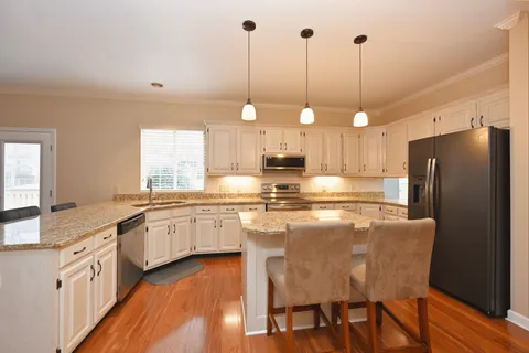 a kitchen with stainless steel appliances granite countertop a refrigerator and a sink