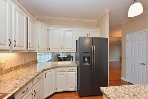 a kitchen with a stove and a wooden floor