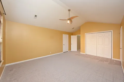 a spacious bedroom with a bed and a chandelier