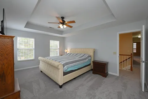 a bedroom with a bed and a chandelier fan