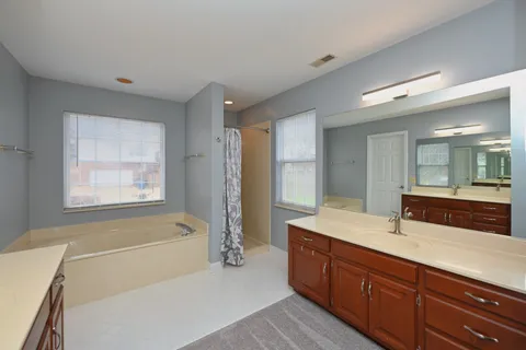 a white bath tub sitting in a bathroom next to a window