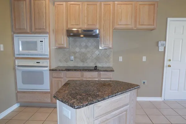 a kitchen with granite countertop a sink and a stove