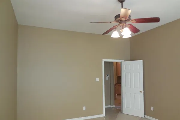 an empty room with a chandelier fan and a chandelier fan
