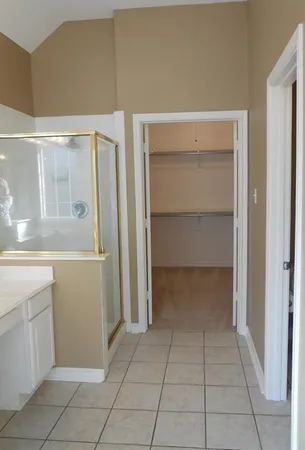 a view of an empty room with cabinet and mirrors