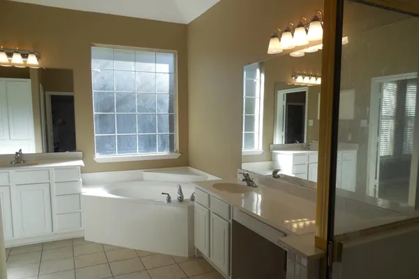 a bathroom with a granite countertop sink mirror and bathtub