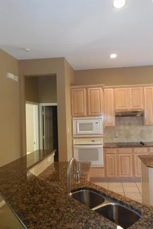 a kitchen with granite countertop a sink and a refrigerator