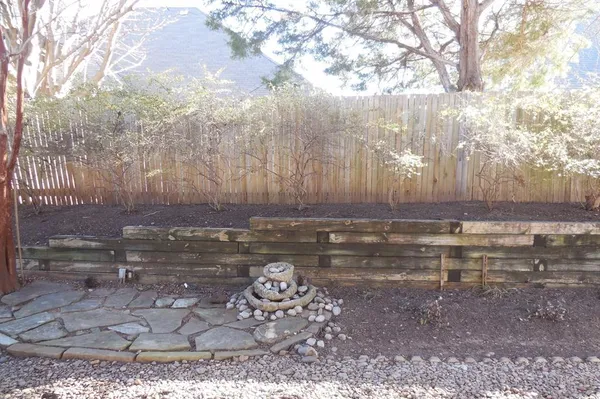 a view of a backyard with a large tree and wooden fence