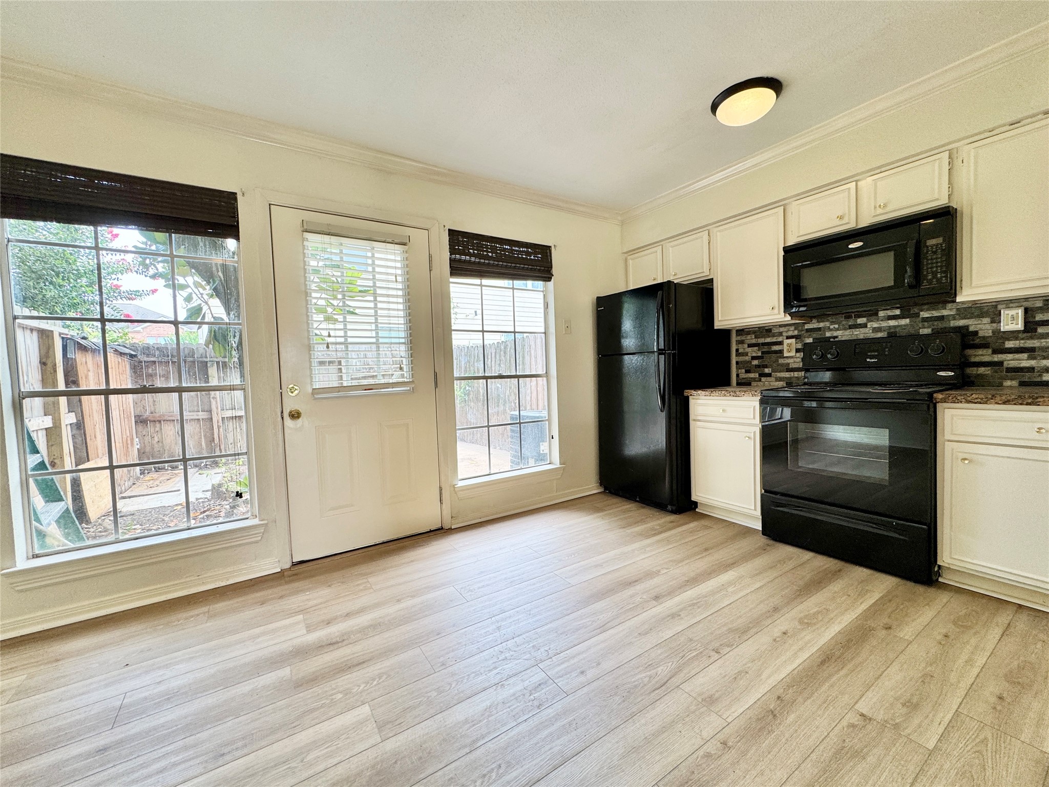 2002 Gentryside Drive, Unit 103 Houston, TX 77077 - Photo 5 of 20 The stylish tile backsplash and modern look white cabinets coordinates well with the sleek black appliances at kitchen.