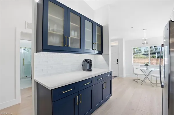 a kitchen with stainless steel appliances granite countertop a stove top oven a sink dishwasher and white cabinets with wooden floor