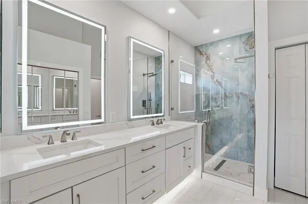 a bathroom with a granite countertop sink a mirror and a bathtub