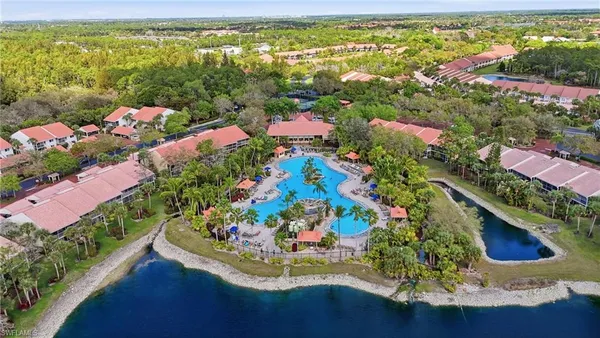 an aerial view of a house with a yard and lake view